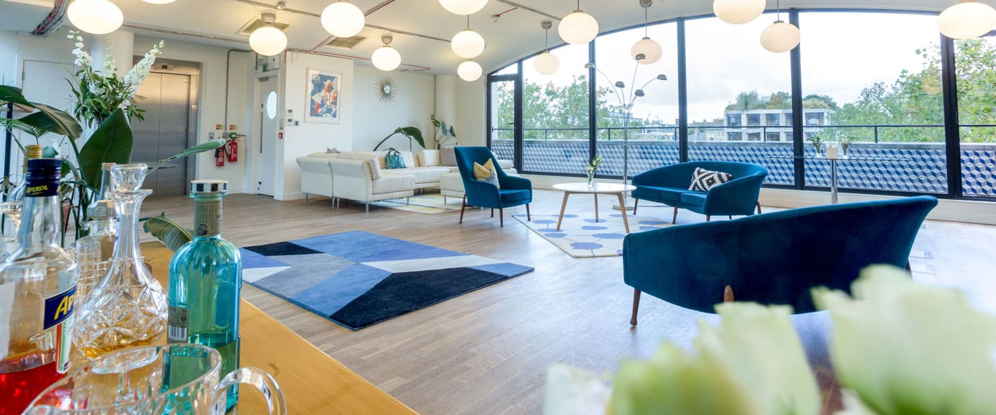 Drinks set out beside sofas and floor-to-ceiling windows.